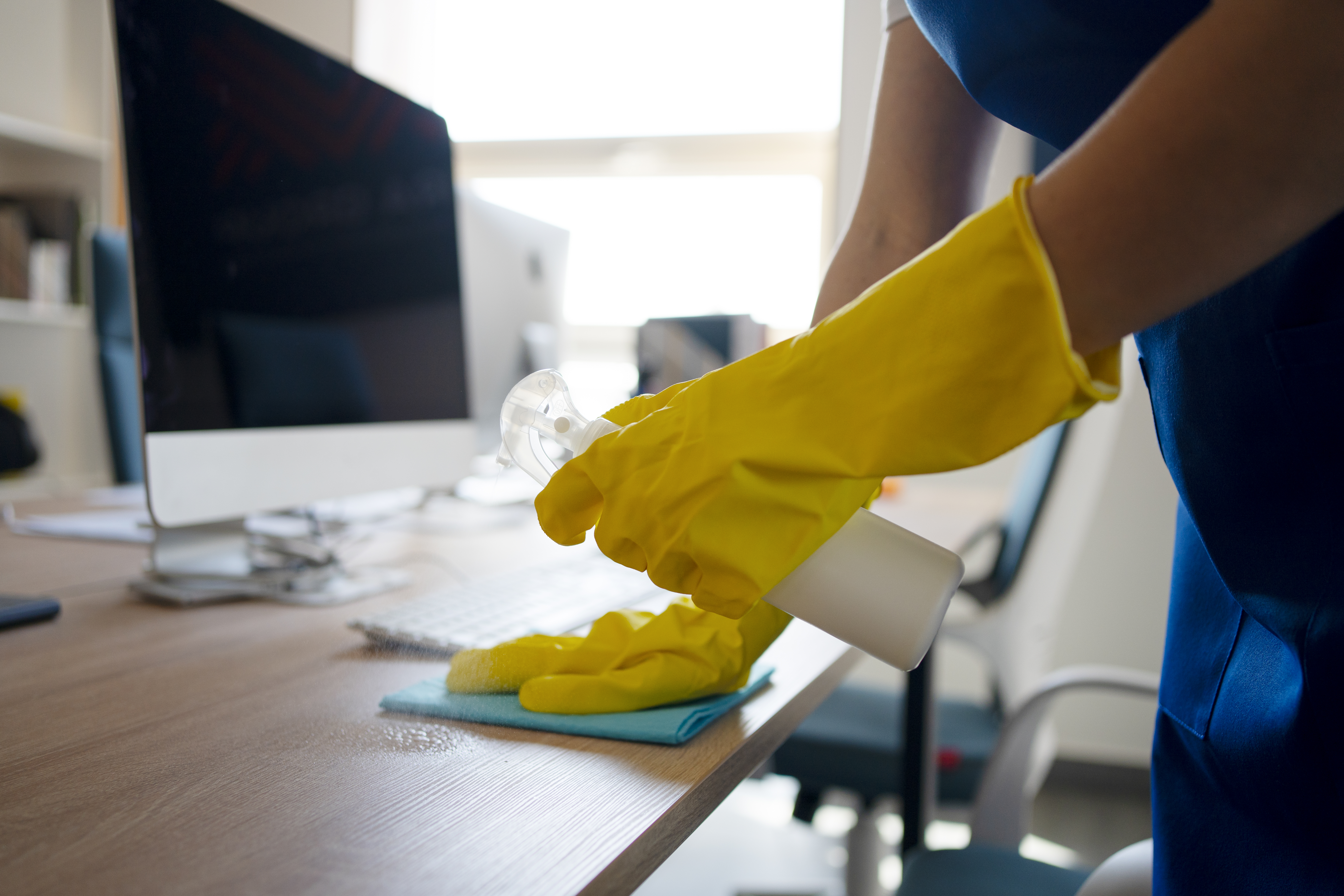 Office cleaning team sanitizing a workspace